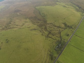 Oblique aerial view centred on the remains of enclosures and field boundaries, taken from the NW.