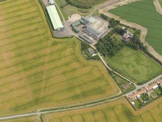 Oblique aerial view centred on the farmhouse and farmsteading and the cropmarks of the enclosure at Greendykes, taken from the W.