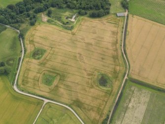 Oblique aerial view of the cropmarks of the enclosure and timber hall at Monboddo, taken from the NNW.