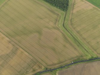 Oblique aerial view centred on the cropmarks of the round house, taken from the NNE.