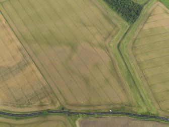Oblique aerial view centred on the cropmarks of the round house, taken from the N.