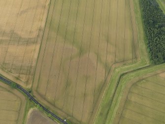 Oblique aerial view centred on the cropmarks of the round house, taken from the NW.