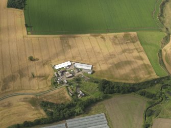 Oblique aerial view centred on the cropmarks of the enclosures, pits, henge, ring ditch and rig, taken from the S.