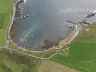Oblique aerial view centred on the farmstead with the ferry terminal adjacent, taken from the N.