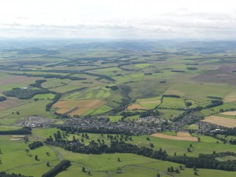 General oblique aerial view centred on the town with the castle and country house in the foreground, taken from the NW.