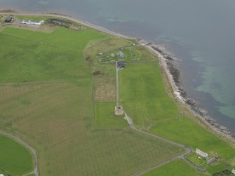 Oblique aerial view centred on the Martello Tower with the early 19th century gun battery adajacent, taken from the SE.