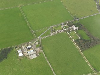 Oblique aerial view centred on the Country House with the Home Farm adjacent, taken from the SSW.