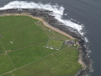 Oblique aerial view centred on the lighthouse with the coastal gun battery adjacent, taken from the SSW.