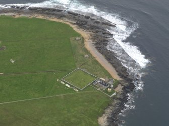 Oblique aerial view centred on the lighthouse with the coastal gun battery adjacent, taken from the SE.