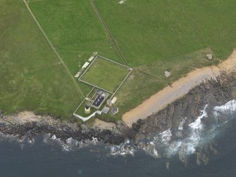 Oblique aerial view centred on the lighthouse with the coastal gun battery adjacent, taken from the N.