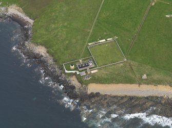 Oblique aerial view centred on Hoy Sound Low lighthouse with the coastal gun battery adjacent, taken from the North West.