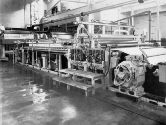 Copy of photograph of paper making machine (no.6), a double VEE tapered breast box of stainless steel and adjustable deckle head with flexible slice control of the flow of stock to the wire. The table rolls and underwire rolls are equipped with sealed ball bearings, as are the deckle pulleys. Three AQUAIR vacuum pumps, two LEITH WALK centrifugal pumps for back water and couch pit trimmings, together with a copper air receiver are installed at the back of the machine, from the JB&S Machine 161 catalogue, James Bertram and Son Ltd, Leith Walk, Edinburgh, circa 1953. The catalogue describes and illustrates some of the features of the No 161 machine 'recently installed at the well known Mill of Guard Bridge Paper Co Ltd, Fife , Scotland designed with the co-operation of the Mill Staff especially for the economical production of the highest quality papers...'