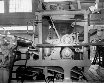 Copy of photograph of paper making machine (no.6), Wet Press Section comprises two presses, the first being the straight through suction type with 'Millspaugh' Suction Roll and the second, a plain reversing press. Both the top granite rollers are carried in roller bearings in spherical housings. The cast-steel levers supporting these rolls are equipped with double acting air cylinders for applying pressure as well as raising clear when changing felts, from the JB&S Machine 161 catalogue, James Bertram and Son Ltd, Leith Walk, Edinburgh, circa 1953. The catalogue describes and illustrates some of the features of the No 161 machine 'recently installed at the well known Mill of Guard Bridge Paper Co Ltd, Fife , Scotland designed with the co-operation of the Mill Staff especially for the economical production of the highest quality papers...'