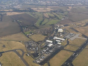General oblique aerial view centred on the air freight centre with the WW II aircraft hangar adjacent, taken from the W.