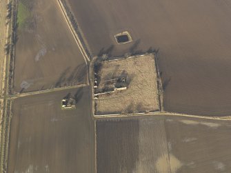 Oblique aerial view centred on the remains of the castle with the remains of the farmstead adjacent, taken from the S.