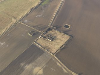 Oblique aerial view centred on the remains of the castle with the remains of the farmstead adjacent, taken from the SE.