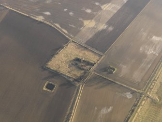 Oblique aerial view centred on the remains of the castle with the remains of the farmstead adjacent, taken from the NW.