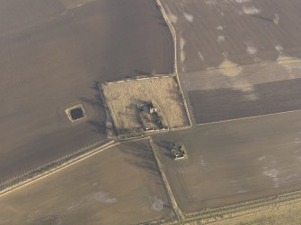 Oblique aerial view centred on the remains of the castle with the remains of the farmstead adjacent, taken from the WNW.