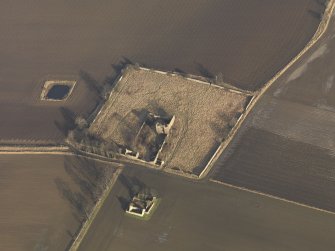 Oblique aerial view centred on the remains of the castle with the remains of the farmstead adjacent, taken from the WSW.