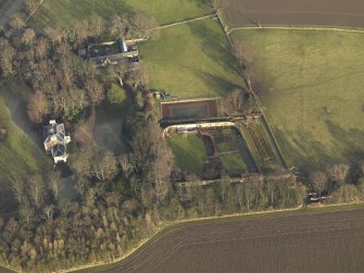 Oblique aerial view centred on the farmhouse with the walled garden and coach house adjacent, taken from the SW.