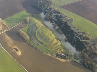 Oblique aerial view centred on the remains of the fort with the farmstead adjacent, taken from the WNW.