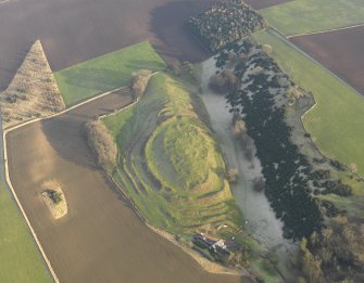 Oblique aerial view centred on the remains of the fort with the farmstead adjacent, taken from the W.