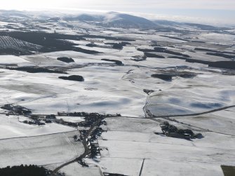 General oblique aerial view looking over the village of Newbigging towards snow-covered Tinto, taken from the NNE.