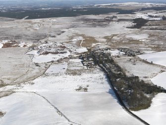 General oblique aerial view of the village and the shale oil works bings, taken from the SSW.