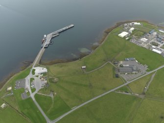 Oblique aerial view centred on part of the airfield with the ferry pier adjacent, taken from the  NW.