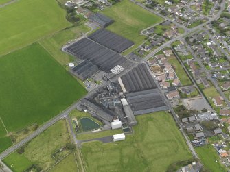 Oblique aerial view centred on the distillery, taken from the SE.