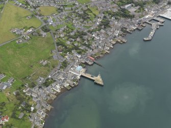 Oblique aerial view centred on the town with the ferry terminal and pier adjacent, taken from the S.
