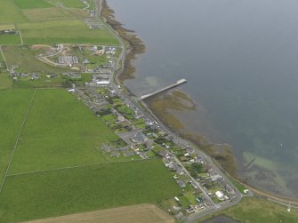 Oblique aerial view centred on the village with the pier adjacent, taken from the WNW.