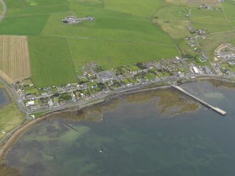 Oblique aerial view centred on the village with the pier adjacent, taken from the SW.