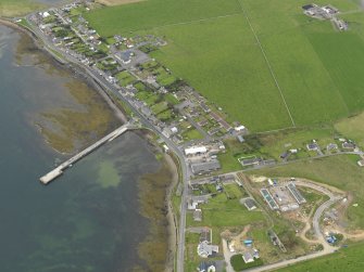 Oblique aerial view centred on the village with the pier adjacent, taken from the SE.