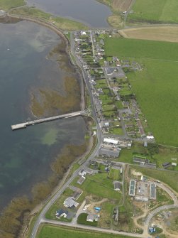 Oblique aerial view centred on the village with the pier adjacent, taken from the E.