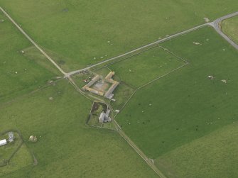 Oblique aerial view centred on the farmhouse with the farmstead adjacent, taken from the ENE.