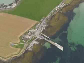Oblique aerial view centred on the village with the ferry pier adjacent, taken from the SE.