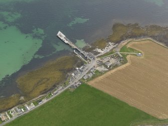 Oblique aerial view centred on the village with the ferry pier adjacent, taken from the NW.