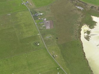 Oblique aerial view centred on the remains of the radar station remote reserve with farmsteads adjacent, taken from the NNE.