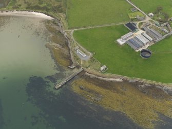 Oblique aerial view centred on the warehouse with the pier adjacent, taken from the SE.