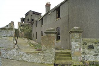 View of cottages with gatepiers and Port War Station in the background, taken from the SSW.