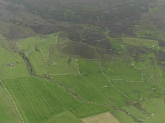 General oblique aerial view of the remains of the chambered cairn, farmsteads and fields at Knowe of Lingro on Rousay, taken from the N.