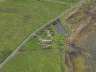 Oblique aerial view centred on the croft house with the slipway adjacent, taken from the NE.