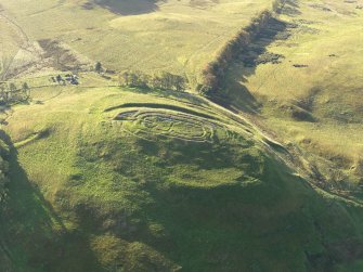 Oblique aerial view centred on the remains of the fort and excavation trenches, with the remains of the framstead adjacent, taken from the N.