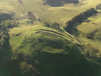 Oblique aerial view centred on the remains of the fort and excavation trenches, with the remains of the framstead adjacent, taken from the NW.