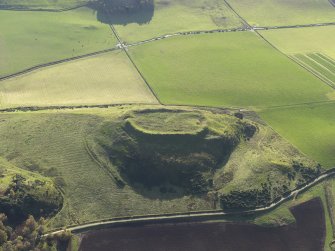 Oblique aerial view centred on the remains of the the fort and the buildings, taken from the NNW.