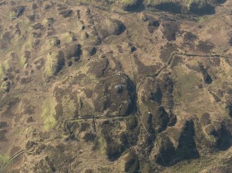 Oblique aerial view centred on the remains of the fort and possible cairn on Ranachan Hill, taken from the NNE.