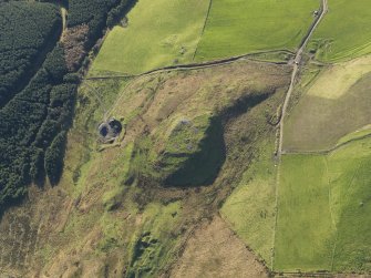 Oblique aerial view centred on the remains of the fort at Largiemore with the remains of the farmstead adjacent, taken from the NNE.