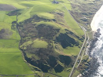 General oblique aerial view of the remains of the fort and landslips, taken from the NNW.