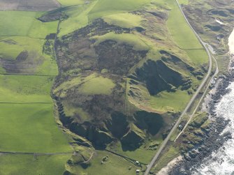 General oblique aerial view of the remains of the fort and landslips, taken from the NNW.